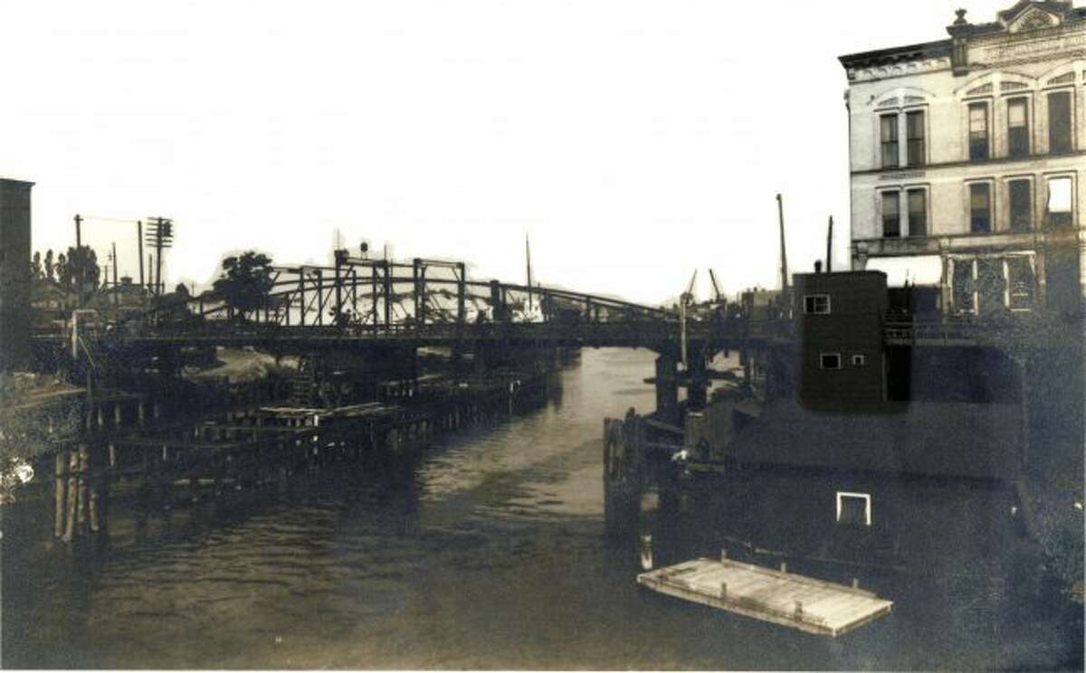 The old version of the Maple Street Bridge from the very early 1900s is shown in this photograph.