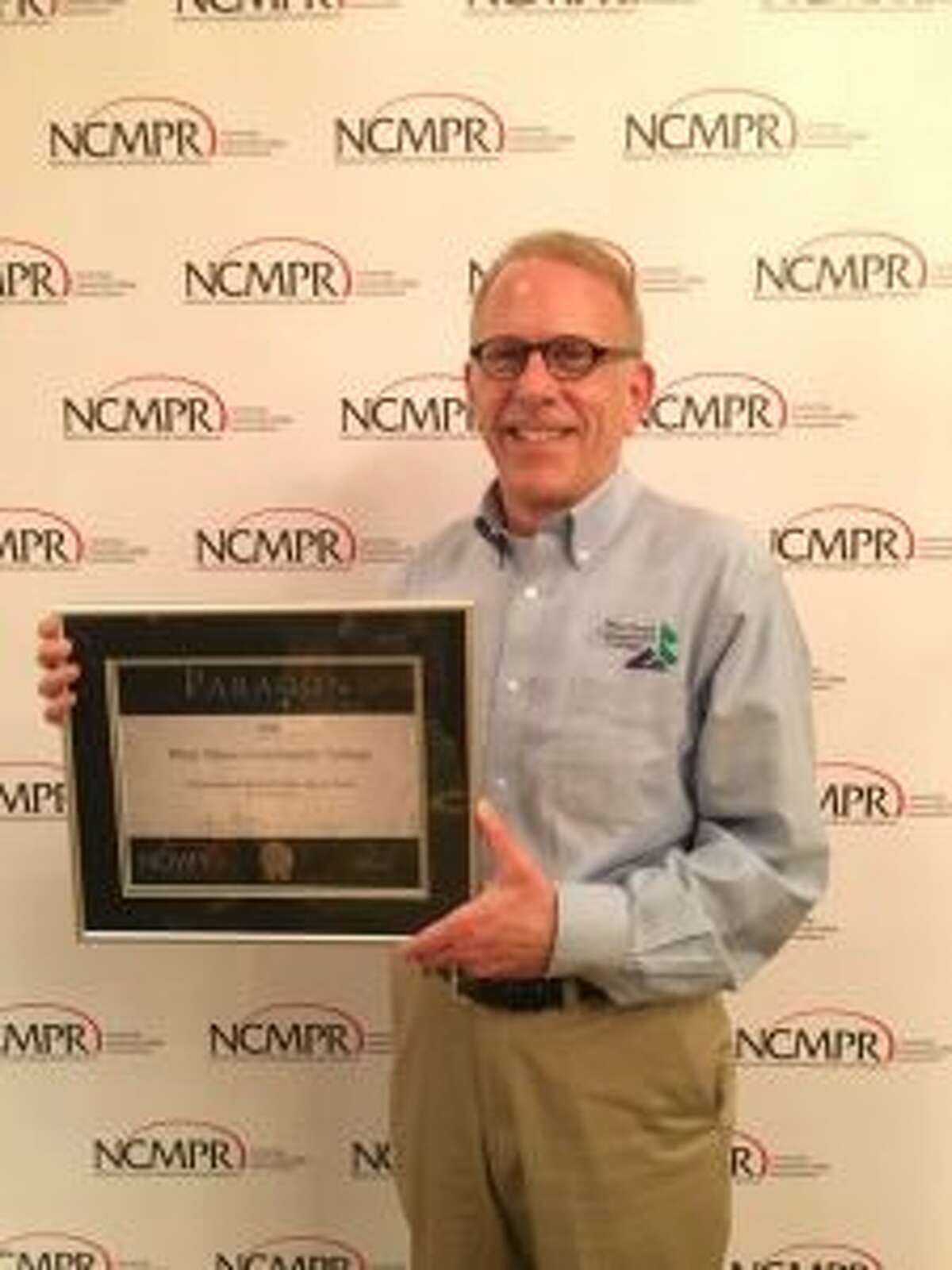 West Shore Community College executive director of college relations Thom Hawley holds the silver Paragon Award the college received from the National Council for Marketing and Public Relations (NCMPR) in the college promotional brand video category.