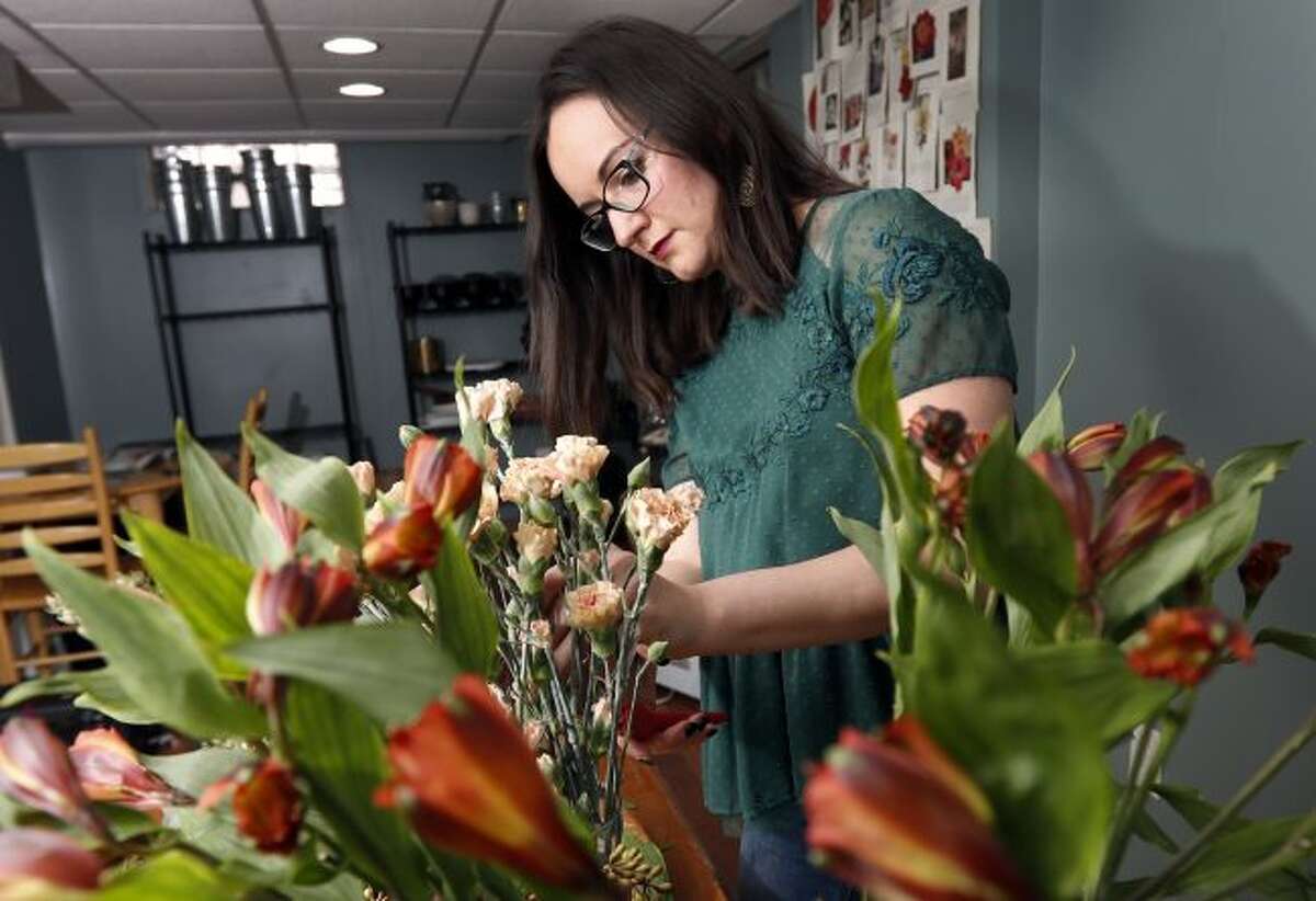 Liz Mally, who owns LPF Blooms, works on a centerpiece on April 1 in her studio in her basement in Ferndale, Mich. Mally learned there is misery in doing work purely for the sake of building a portfolio. “I was taking on pretty much any client I could get, regardless of budget or style, in hopes of gaining experience and getting my name out there,” said Mally. (AP Photo/Carlos Osorio)