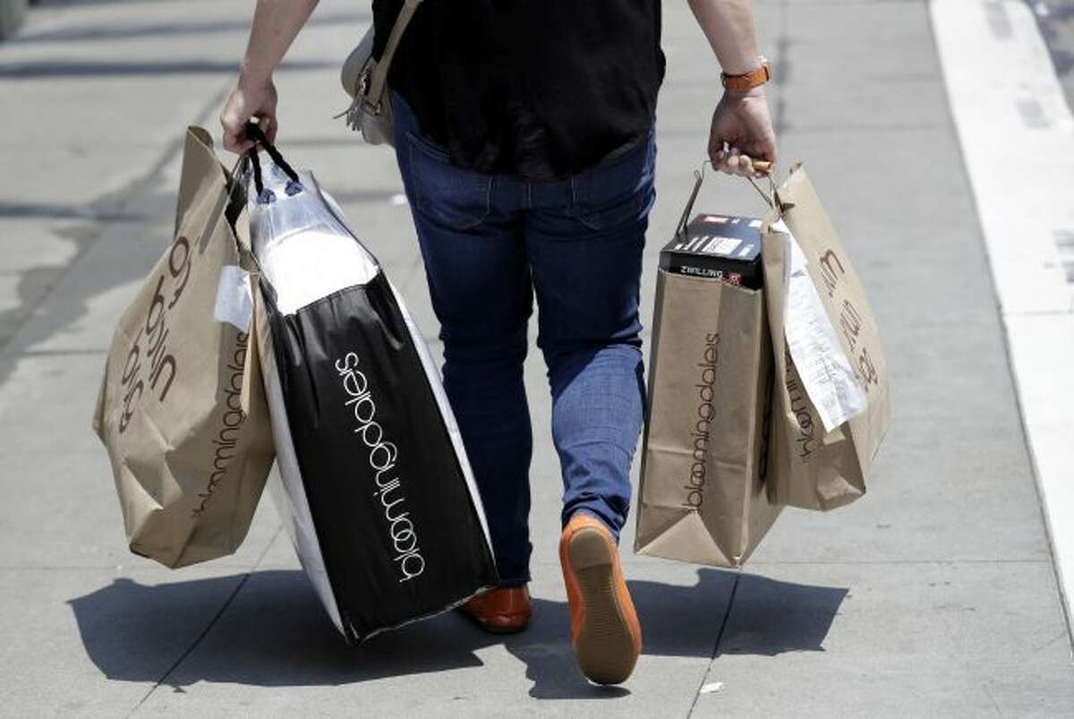 A shopper carries bags in San Francisco on July 3, 2018. American consumers are feeling more confident this April 2019, though optimism hasn’t fully recovered from a period of roiling markets and slowed hiring early this year. The Conference Board, a business research group, said Tuesday that its consumer confidence index rose to 129.2 in April, from 124.2 in March. (AP Photo/Marcio Jose Sanchez, File)