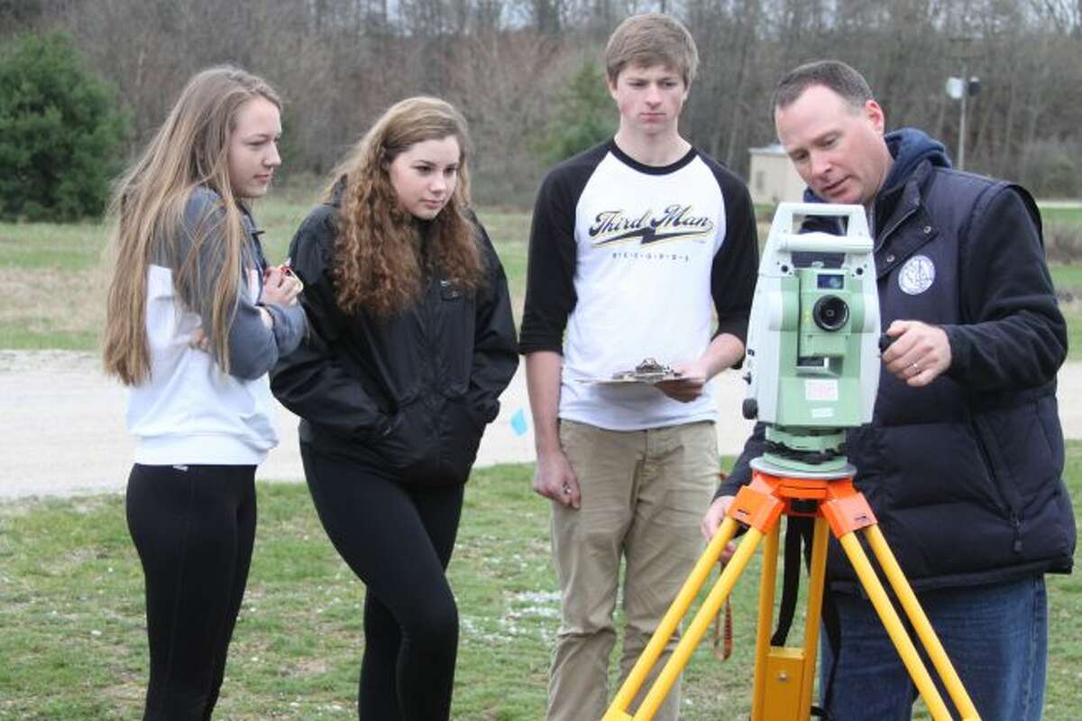 Spicer Group and Manistee County surveyor Pat Bentley shows Manistee High School trigonometry students how to use the surveying equipment to solve the problems for the Trig Star lesson. Every year Bentley works with the students showing them practical use of trigonometry in the real world.