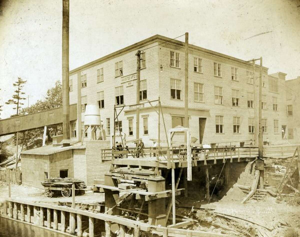 The Manistee Manufacturing Company is shown in this late 1800s picture behind the Maple Street bridge that is under construction.