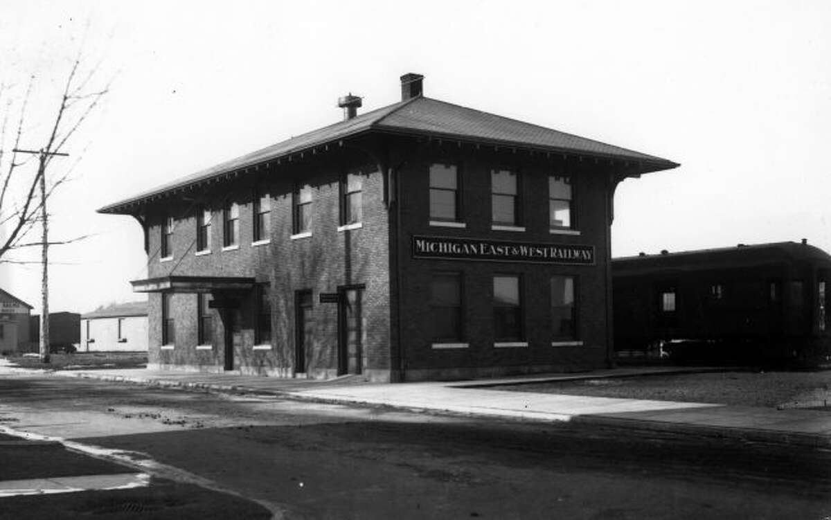 The Michigan East & West Railway Depot is shown in the picture from the early 1900s and was located on River Street. The building most recently was used as the Johnson Funeral Home.