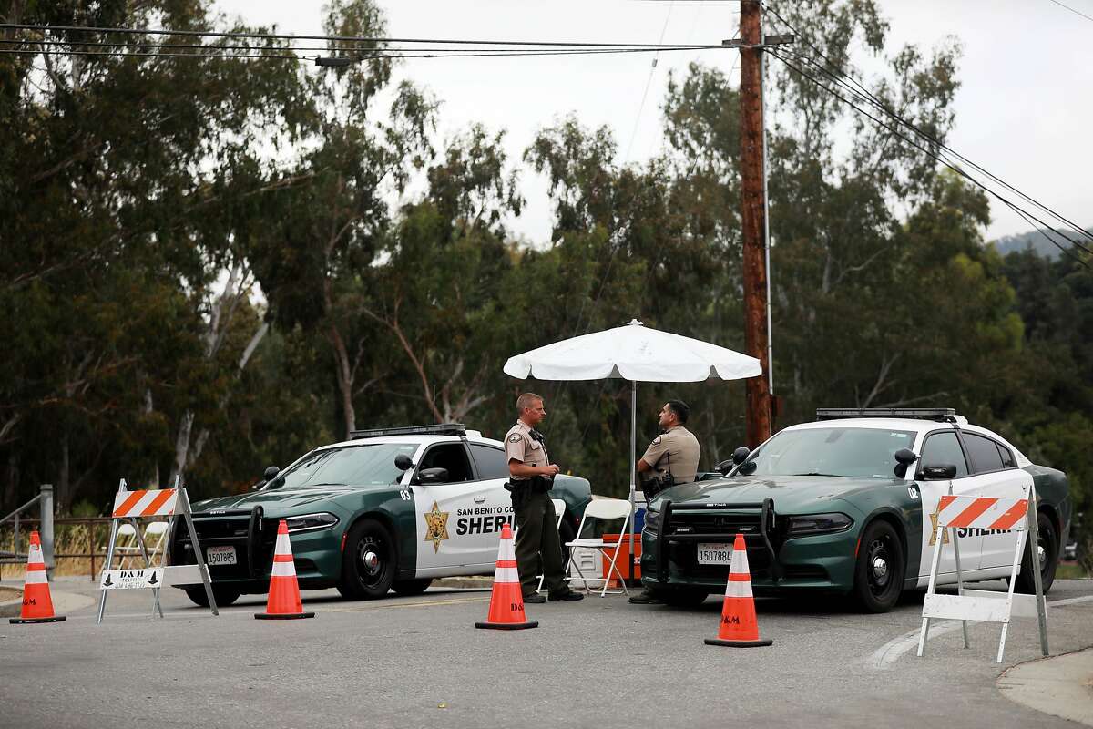 Two officers with the San Benito County Sheriff's office stand guard at the corner of Miller Ave. and Uvas Park Dr., near Christmas Hill Park, in Gilroy, Calif., on Tuesday, July 30, 2019.
