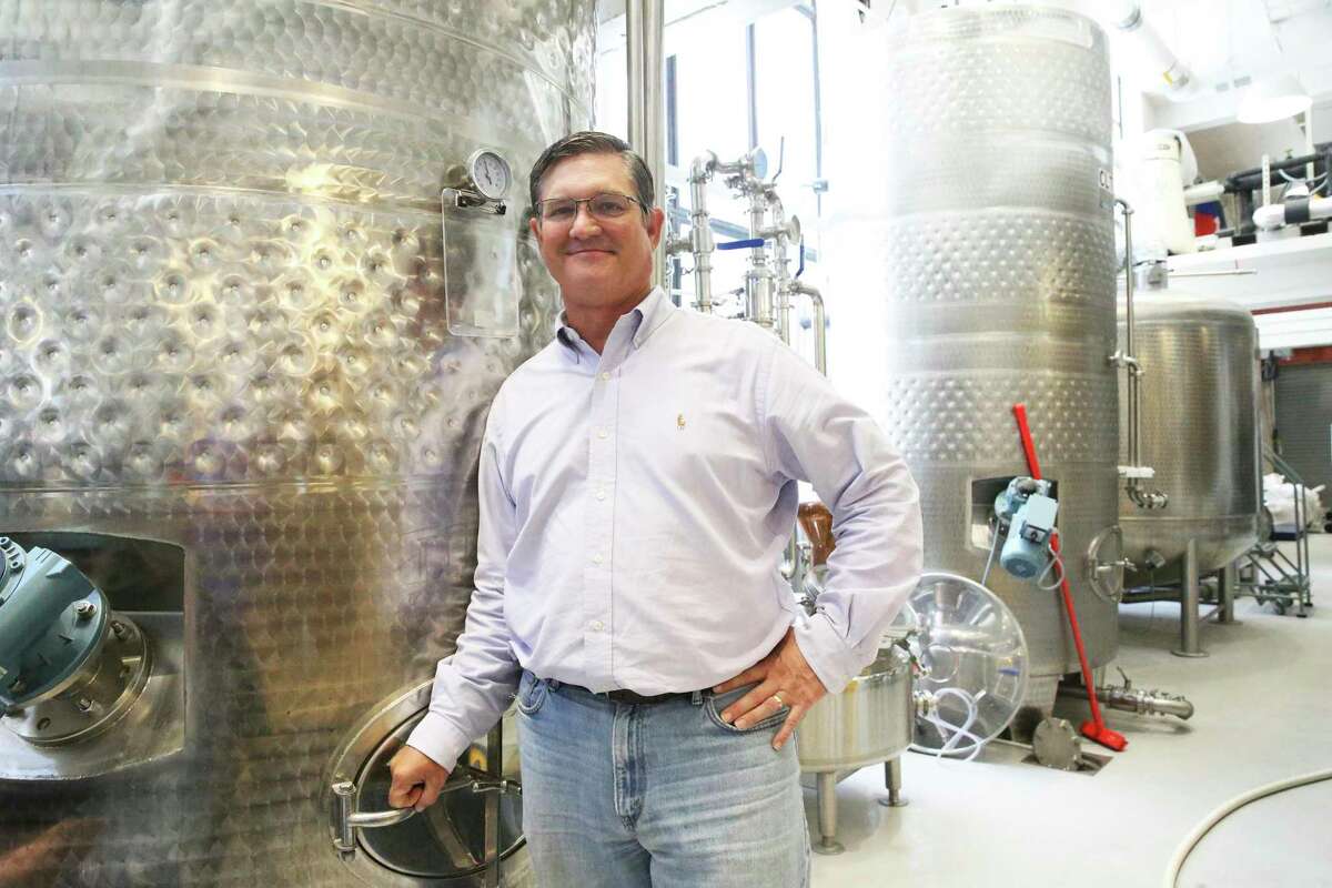 Architect Greg Shue stands near brewing containers at Maverick Distillery.