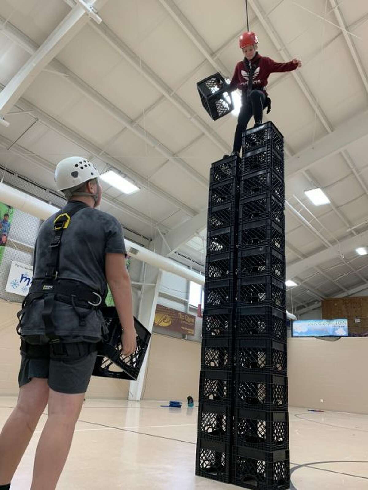 Nate Corey participates in the crate stacking challenge, as he is supported and encouraged by his classmate Adam Domres.