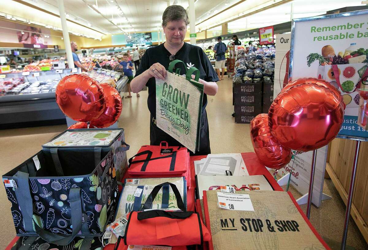 Stop & Shop employee Sonja Foxwell shows some of the reusable bags and community bags in Wallingford, Conn. (Dave Zajac/Record-Journal via AP)