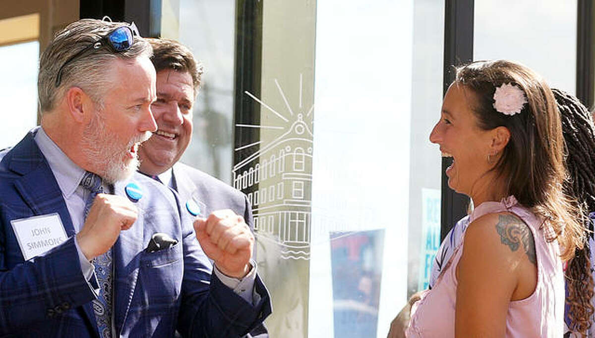 John Simmons jokes with Alton Main Street Executive Director Sara McGibany, as Illinois Gov. J.B. Pritzker looks on Tuesday during the Grand Opening of the AltonWorks office.