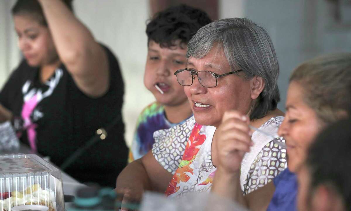 Ignacia Cuz, center, gets help from neighborhood friends celebrating her 55th birthday at Devine Redeemer Presbyterian Church which shares activity space with House of Neighborly Service, on Tuesday, July 30, 2019. At her side is her son Sammuel Hernandez, 11, and freinds Diana Mendoza, left, and Damari Aleman, right. Cruz not only works at HNS, but also has two and sometimes 3 other jobs just to make ends meet. Cruz's friends all pitched in for the cake, but the church donated the hotdog dinner. Afterward, they all played Loteria.