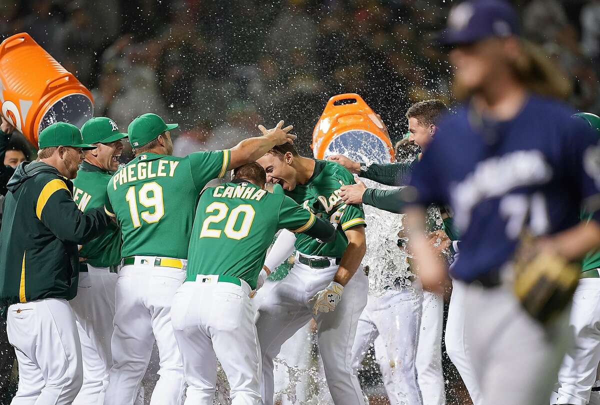 OAKLAND, CA - JULY 30: Matt Olson #28 of the Oakland Athletics and his teammates celebrate after Olson hit a walk-off solo home run in the bottom of the 10th inning to defeat the Milwaukee Brewers 3-2 at Ring Central Coliseum on July 30, 2019 in Oakland, California. (Photo by Thearon W. Henderson/Getty Images)