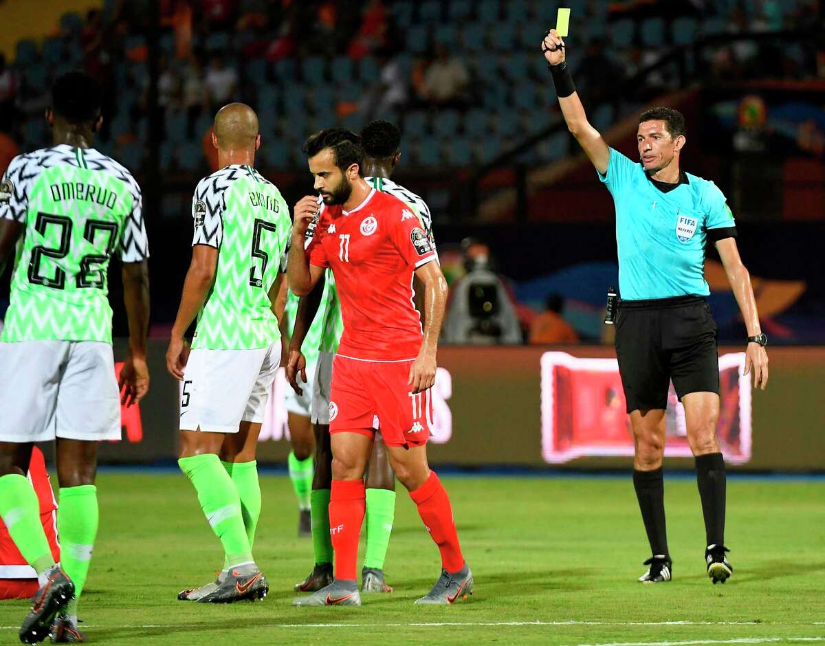An Egyptian refereee shows a yellow card to Nigerian defender during a recent international soccer game.