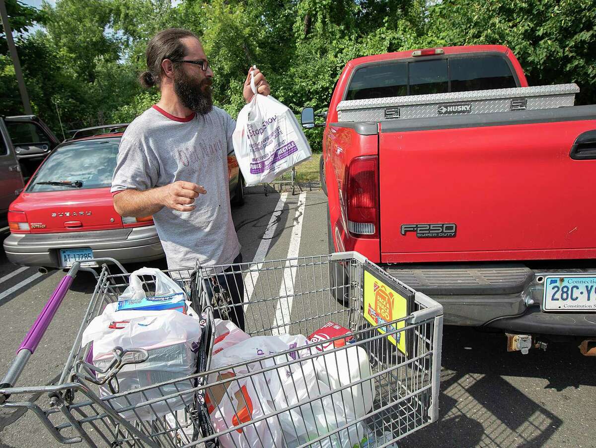 In this Monday, July 29, 2019, photo Andrew Sanchez packs groceries into his pickup after shopping at Stop & Shop in Wallingford, Conn. The grocery store chain Stop & Shop says it is eliminating single-use plastic bags at checkout at its Connecticut stores. (Dave Zajac/Record-Journal via AP)