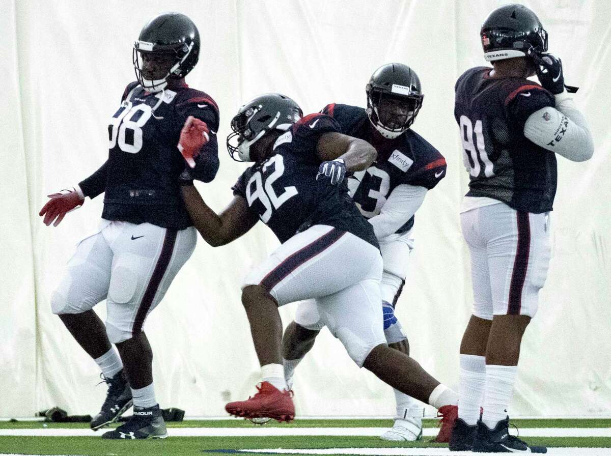 Houston Texans nose tackle Brandon Dunn (92) runs a drill against defensive ends D.J. Reader (98) and Joel Heath (93) during training camp at the Methodist Training Center on Wednesday, July 31, 2019, in Houston.