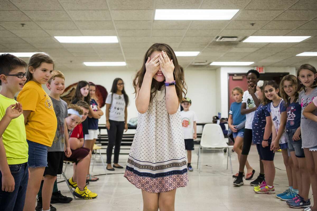 Lorelai Boldt covers her eyes while walking between two lines of classmates during the second session of a weeklong improv camp on Tuesday, July 30, 2019 at Midland Center for the Arts. (Katy Kildee/kkildee@mdn.net)