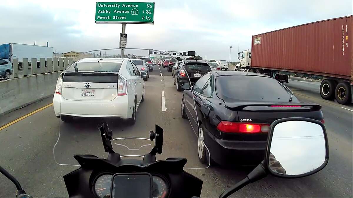 Lane-splitting through gridlock on Interstate-80 in Berkeley. There isn't a lot of room between these two cars (and my luggage) so I'm only doing 15 here.﻿
