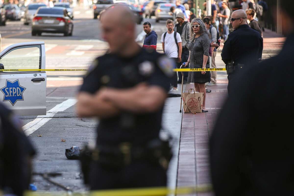 Onlookers watch San Francisco Police Officers near Market Street and 5th Street where a police officer allegedly shot a dog Wednesday, July 31, 2019, in San Francisco, Calif.