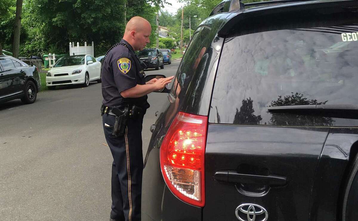 Fairfield Police Officer Jeff Wikman hands out a ticket during April's distracted driving enforcement. Fairfield,CT. 5/3/17