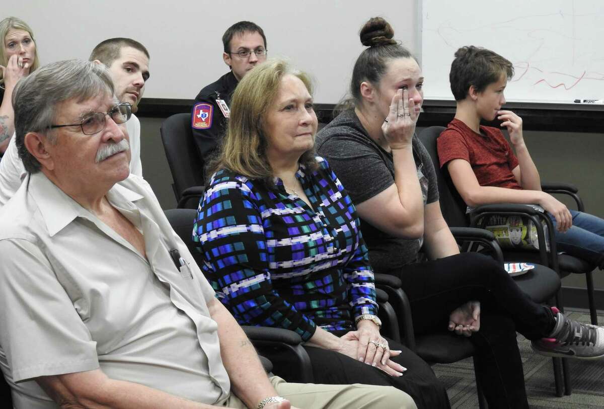 Evelyn Huddleston sits in between her husband Wayne, left, and granddaughter Christine Luke, right, during a reunion between her and the Montgomery County Hospital District first responders who helped save her life after she went into cardia arrest.