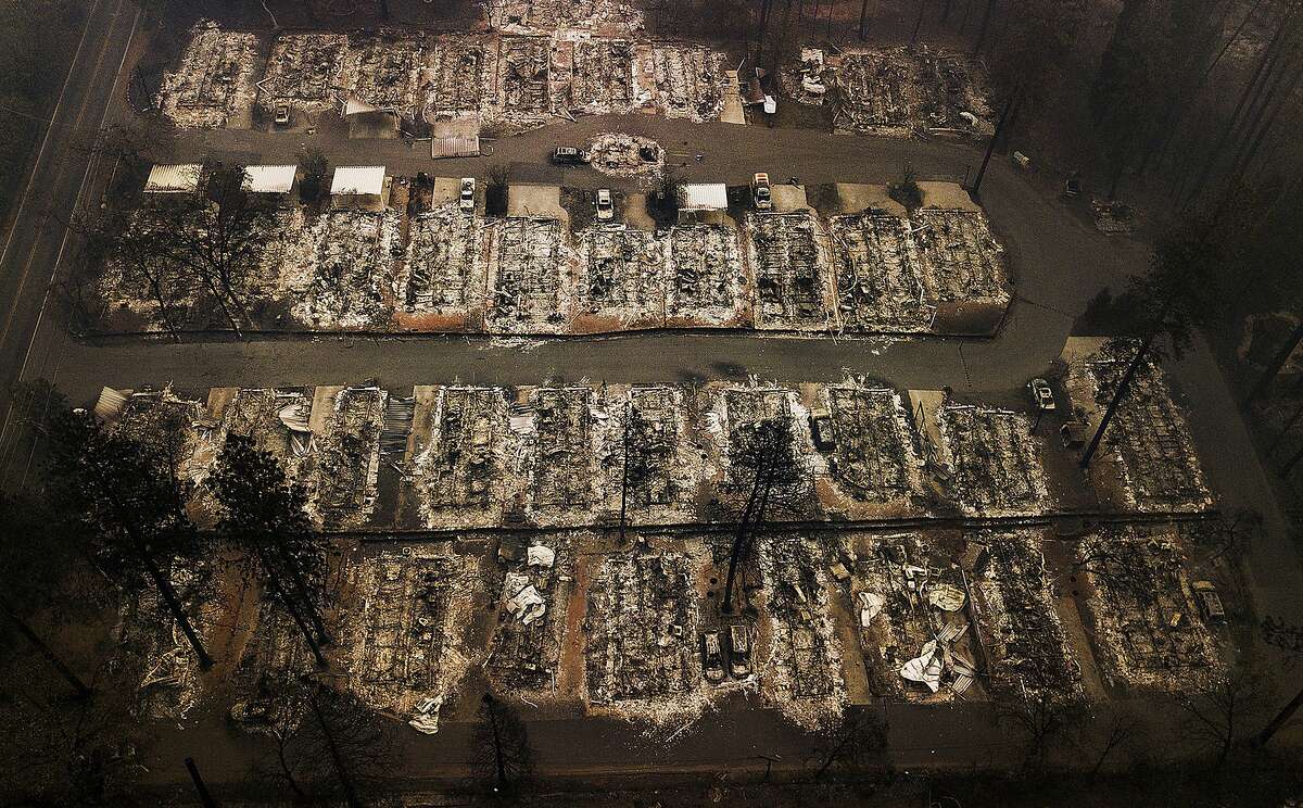 FILE - This Nov. 15, 2018, aerial file photo shows the remains of residences leveled by the Camp wildfire in Paradise, Calif. A group of insurance companies are offering a plan to take over Pacific Gas & Electric, the latest to offer competing proposals to pay the utility's wildfire liabilities and pull it out of bankruptcy. In court filings Tuesday, July 23, 2019, the insurers said PG&E Corp. owes them more than $20 billion in claims paid to victims of recent California wildfires caused by PG&E equipment and offered a "viable path" to emerge from bankruptcy. (AP Photo/Noah Berger, File)