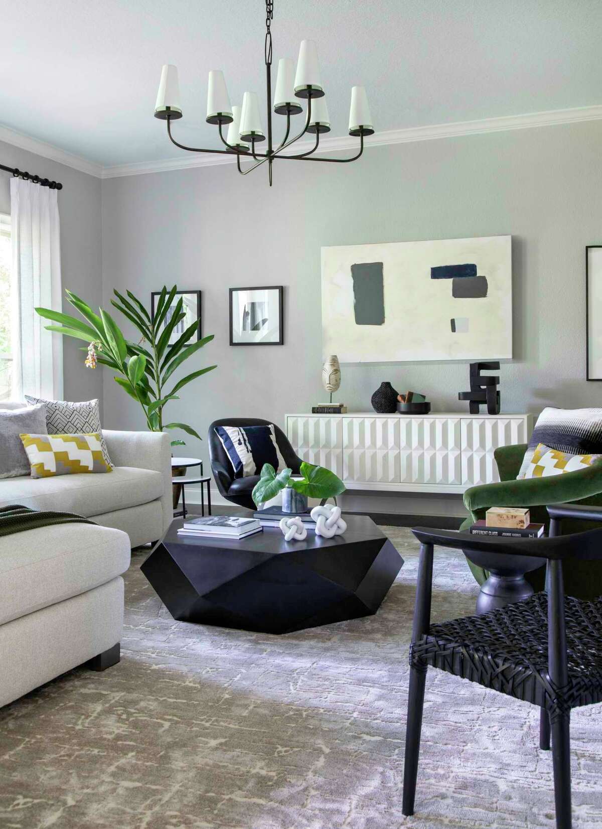 Gerald Johnson Jr.'s Dickinson home was reinvented with "Parisian modern" inspiration. His interior designer, Jacob Medina of Medina Designs, painted most of the interiors Sherwin-Williams Repose Gray and used a mix of neutrals with pops of color, like the green sofa in the living room.