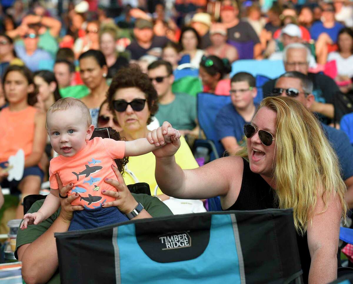 Ten-month-old Spencer Elliott of Stamford dances with his mother Sarah O'Mahoney-Elliott as they enjoy Raquel de Souza, lead singer for Raquel and The Wildflowers performance at the Wednesday Nite Live in Stamford, Conn. on July 10, 2019. Hundreds of music fans packed into Stamford's Columbus Park to enjoy the up and coming country rock band as they opened for headliner Andy Grammer, who kicked off to the annual summer concert series.