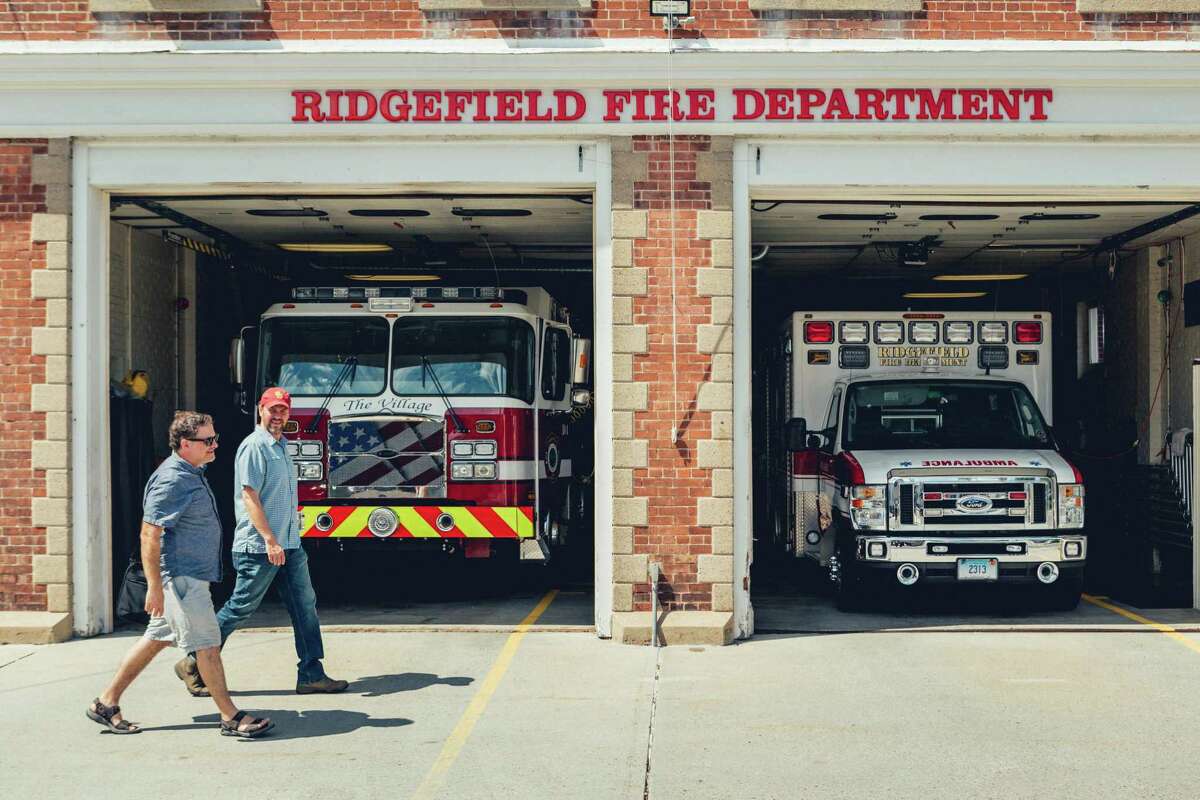 Thrown Stone Theater Company co-artistic directors from left to right Jason Peck and Jonathon Winn pass by the Ridgefield Fire Department of Ridgefield, CT.