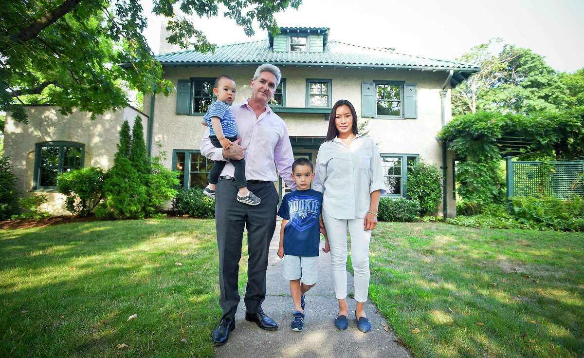Peter Zeitsch, stands with his wife, Flora, and their sons, 5-year-old Luke and 18-month-old Mark, in front of their home in the Shippan section of Stamford, Conn., on July 30, 2019. The Zeitsches relocated from San Francisco and moved in June to the Italian villa-style house, which stands on Shippan Avenue. The home’s approximately $1 million sale to the Zeitsches was brokered by Halstead Real Estate.