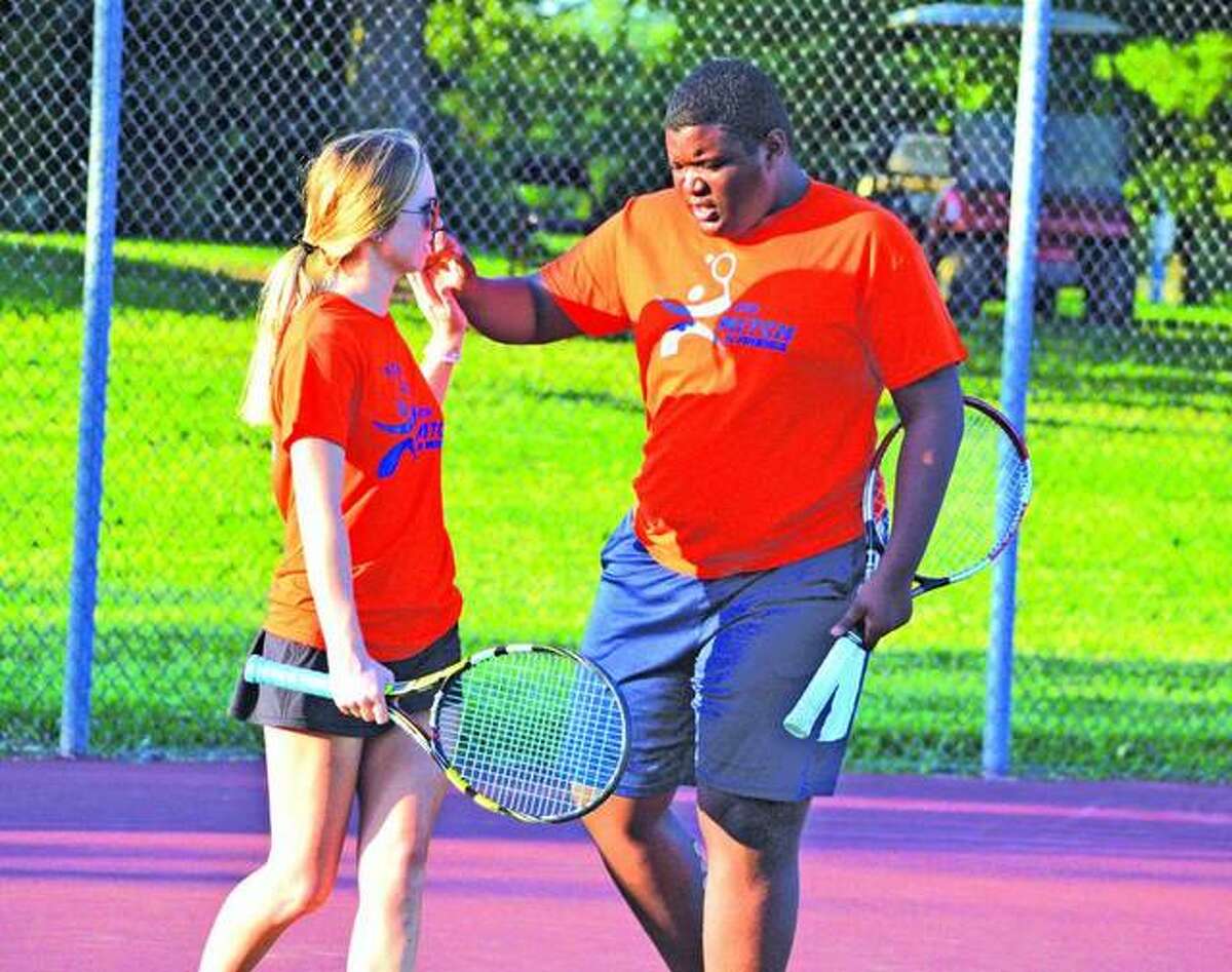 Michael Kwasa, right, exchanges high fives with EHS player Annie McGinnis during the seventh annual Mitch n’ Friends night last year at the EHS Tennis Center.