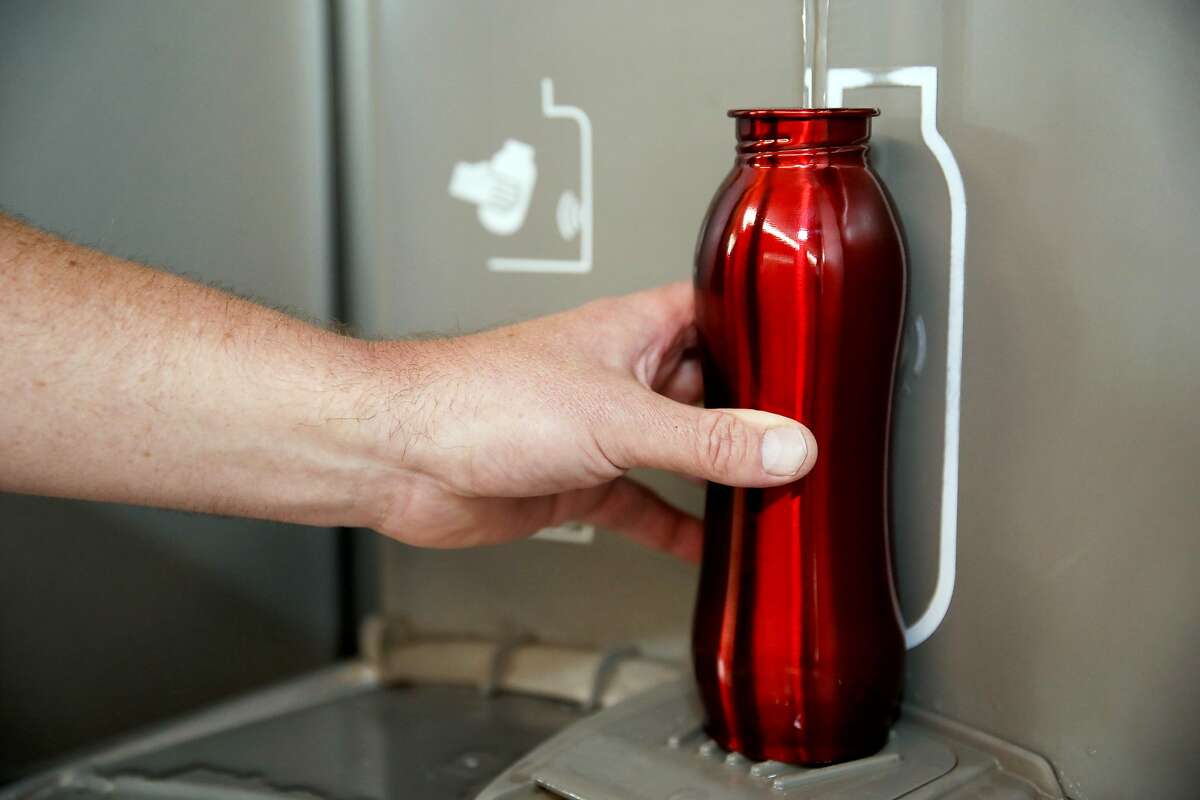 Traveler Emile Monette, of the D.C. area, refills his water bottle at a hydration station in Terminal 3 at the San Francisco International Airport in San Francisco, Calif., on Thursday, August 1, 2019. The airport will require vendors to cease selling water in plastic bottles beginning August 20, replacing them with glass bottles or aluminum cans.