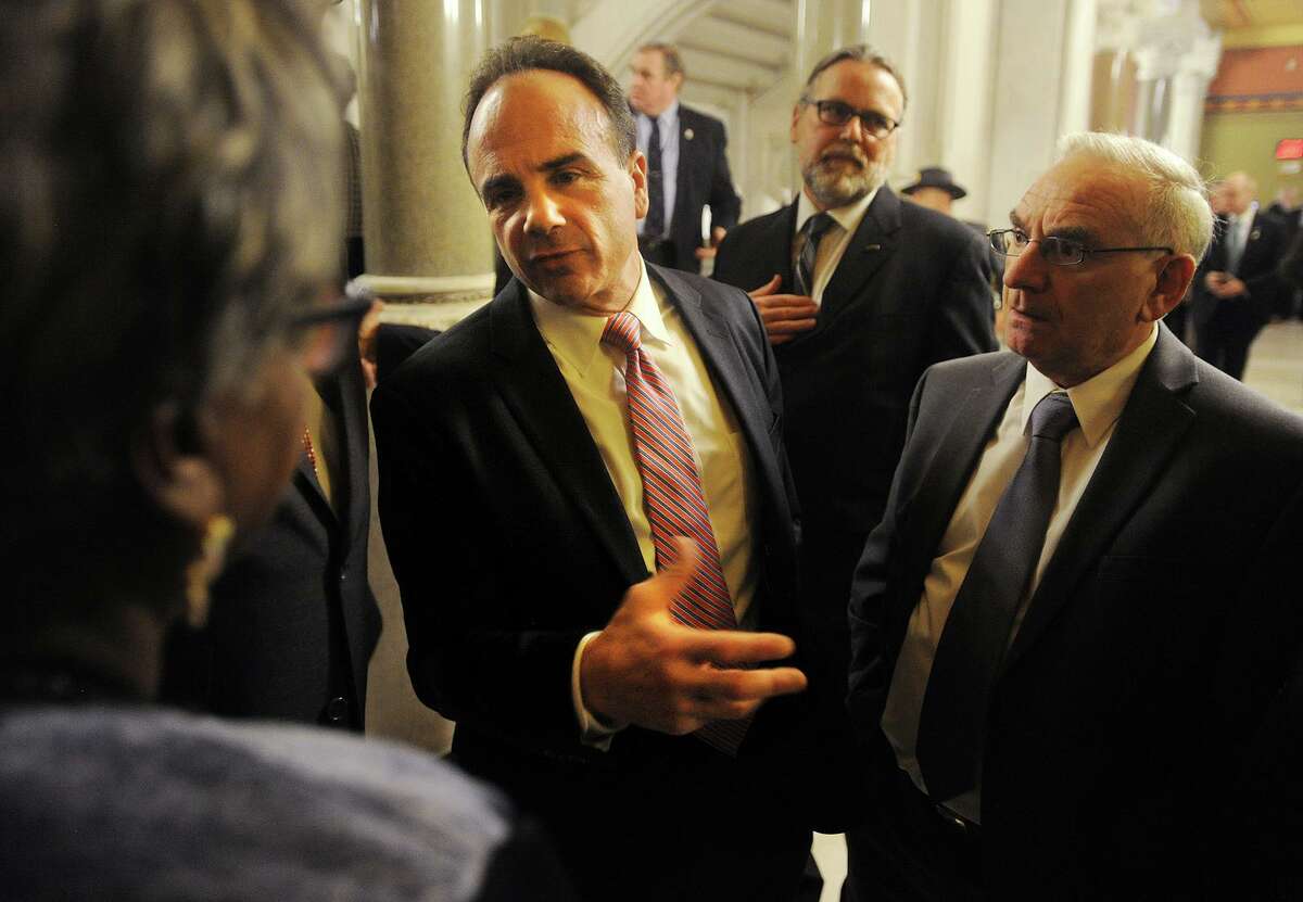 Bridgeport Mayor Joe Ganim talks with Sen. Marilyn Moore, left, outside the House of Representatives where he attended Gov. Dannel P. Malloy's budget address at the Capitol in Hartford, Conn. on Wednesday, February 3, 2016. Attending with Ganim was Bridgeport Democratic Town Committee Chair Mario Testa, right.