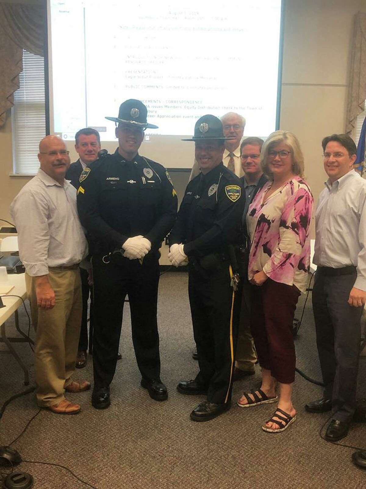 Officer Anthony Armeno, left, was promoted to corporal and Officer Robert Burke, right, will be the new Heritage Village Community Resource Officer. Both are pictured with the Board of Selectmen at the Aug. 1 Board of Selectmen meeting in Southbury, Conn.
