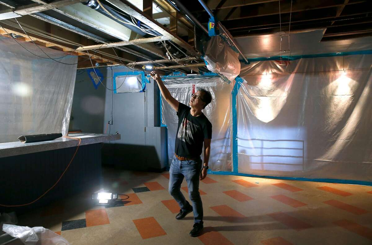 Biscuits and Blues owner Steven Suen inspects the damage to his ceiling and nightclub in San Francisco, Calif. on Friday, Aug. 2, 2019 caused by flooding from the restaurant above. The Biscuit and Blues nightclub has remained closed since April 4 when a sewage line from the Jack in the Box restaurant on the floor above cracked, sending waste water raining down from the ceiling of the club.
