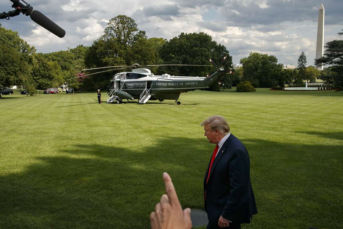 A reporter tries to get the attention of President Donald Trump as the president finishes speaking to the media about the Congressional testimony of former special counsel Robert Mueller, Wednesday, July 24, 2019, on the South Lawn of the White House in Washington. (AP Photo/Jacquelyn Martin)