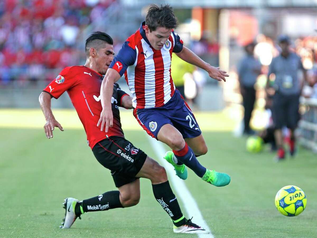 Chives Carlos Fierro, right, tries to get past Atlas's Jose Antonio Madonna from Liga MX soccer exhibition match between Chivas and Club Atlas on Wednesday, July 5, 2017