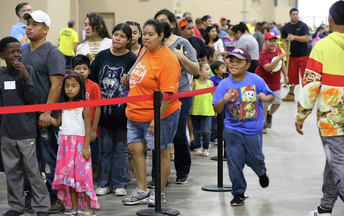 A large attendance of parents with their children wait in line at the Expo Hall at Freeman Coliseum for the annual back-to-school event on Saturday, Aug. 3, 2019. Backpacks and school supplies were handed out for free at the event by various local and corporate businesses. Health screenings were available and vouchers were given for haircuts. Booths operated by private companies and nonprofits offered additional supplies at the event which at one point had lines extending outside the hall. (Kin Man Hui/San Antonio Express-News)