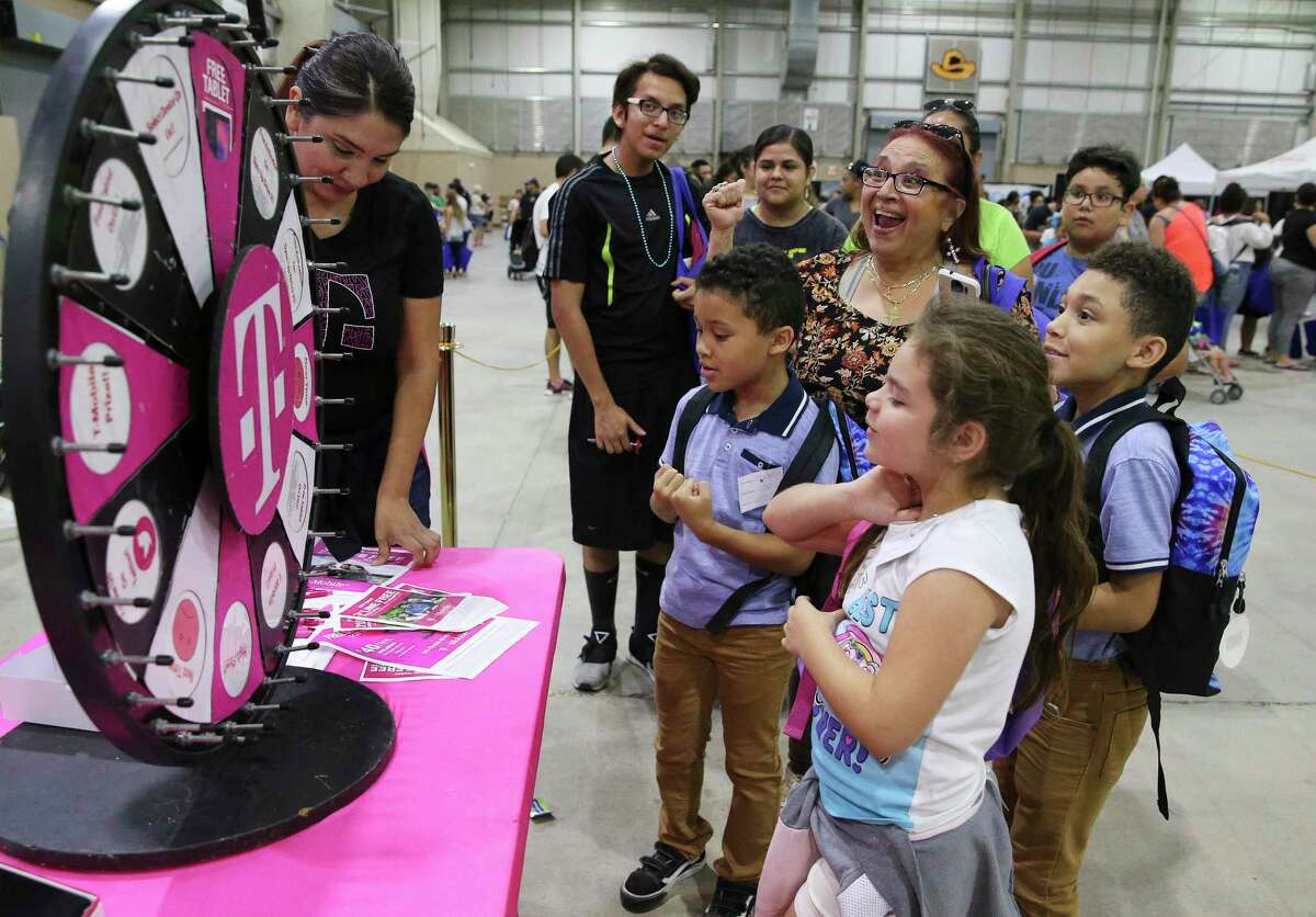 Grandmother Ida Bustillos reacts with joy as her granddaughter Cristiana Mercado, 7, wins the smart tablet award at the T-Mobile booth as a large turnout of parents with their children fills the room. exhibition at the Freeman Coliseum for the start of the annual school year.  school event on Saturday August 3, 2019.