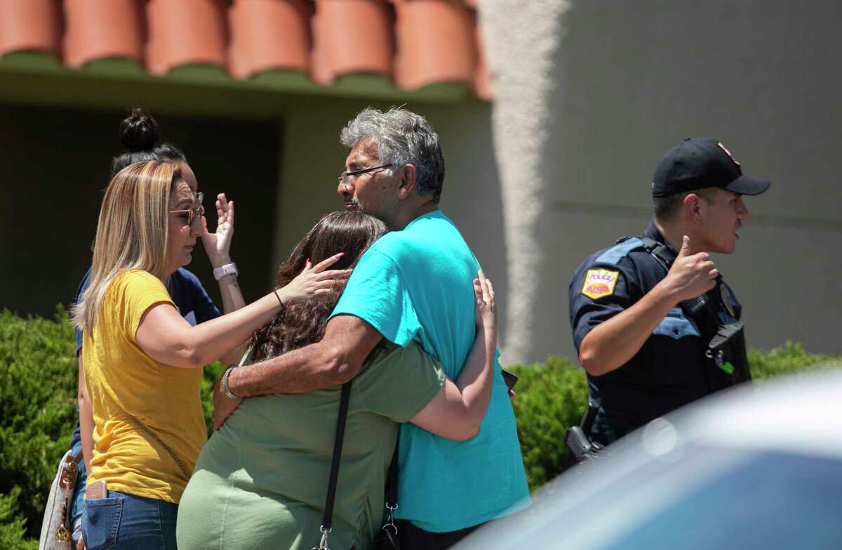 A family embraces near the Walmart where a man opened fire on back-to-school shoppers, Saturday, August 3, 2019, in El Paso, Texas. Multiple people are dead after a mass shooting at an El Paso Walmart on Saturday. The mayor says three people are in custody for the shooting but the El Paso police spokesman says there was only one shooter.