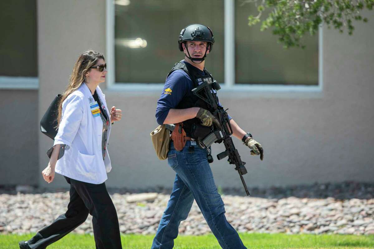 A Walmart pharmacy employee is escorted from the scene by law enforcement after a gunman opened fire on back-to-school shoppers on Saturday, August 3, 2019, in El Paso, Texas. Multiple people are dead after a mass shooting at an El Paso Walmart on Saturday. The mayor says three people are in custody for the shooting but the El Paso police spokesman says there was only one shooter.