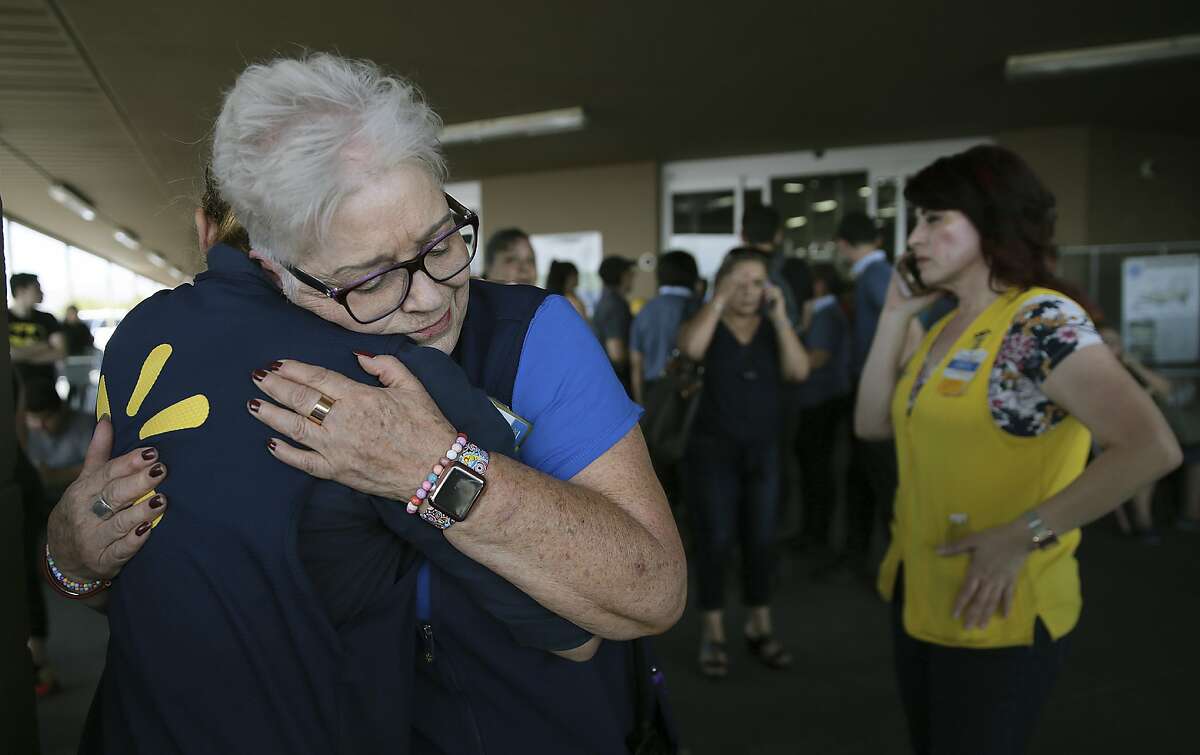 Walmart employees comfort one another after an active shooter opened fire at the store in El Paso, Texas, Saturday, Aug. 3, 2019.