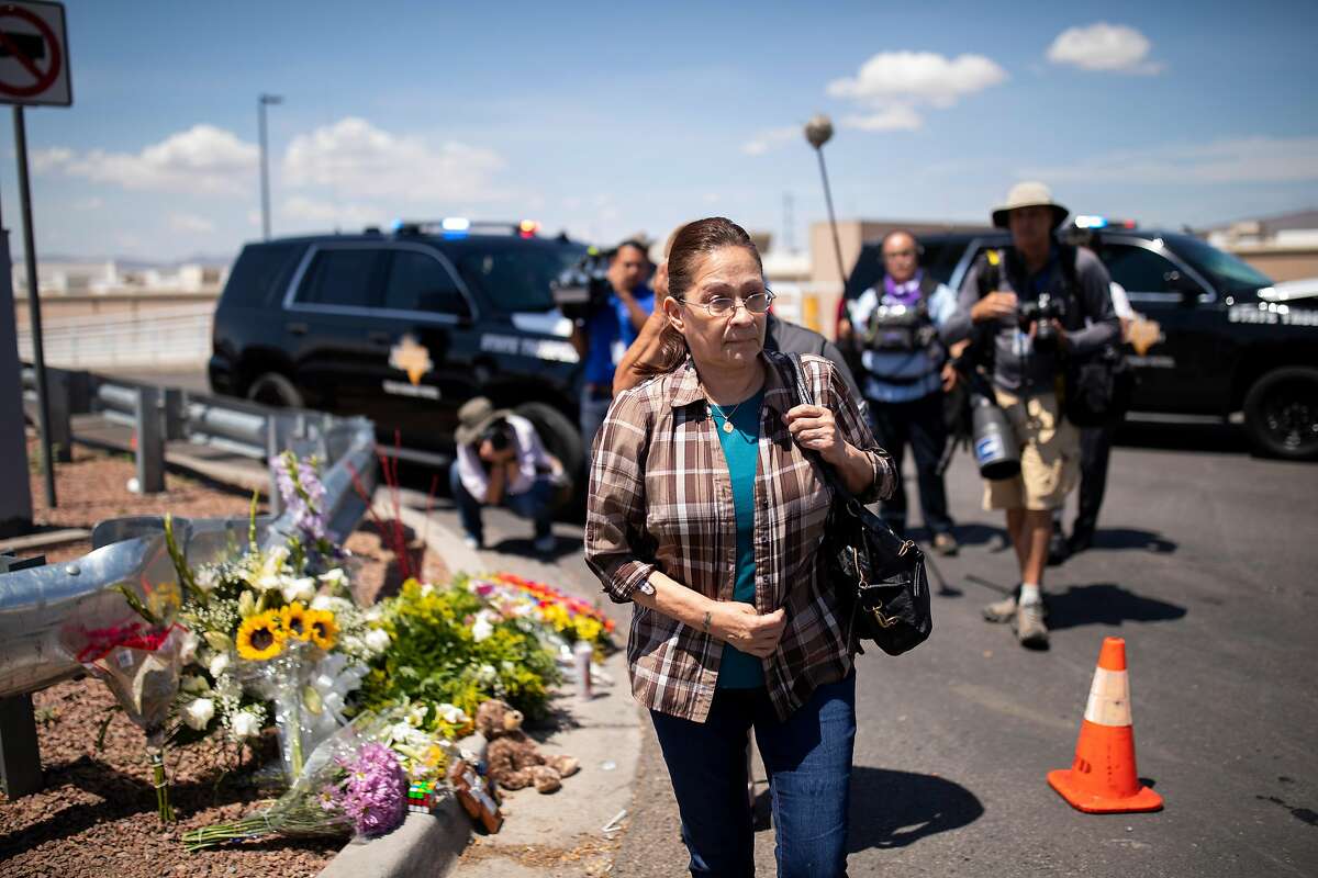 Mary Murillo leaves after praying and leaving flowers at a makeshift memorial near the Walmart where 20 people were killed Saturday, in El Paso, Texas, Aug. 4, 2019. Federal investigators in El Paso said they were treating the shooting as an act of domestic terrorism and prosecutors were considering federal hate crime charges. (Ivan Pierre Aguirre/The New York Times)
