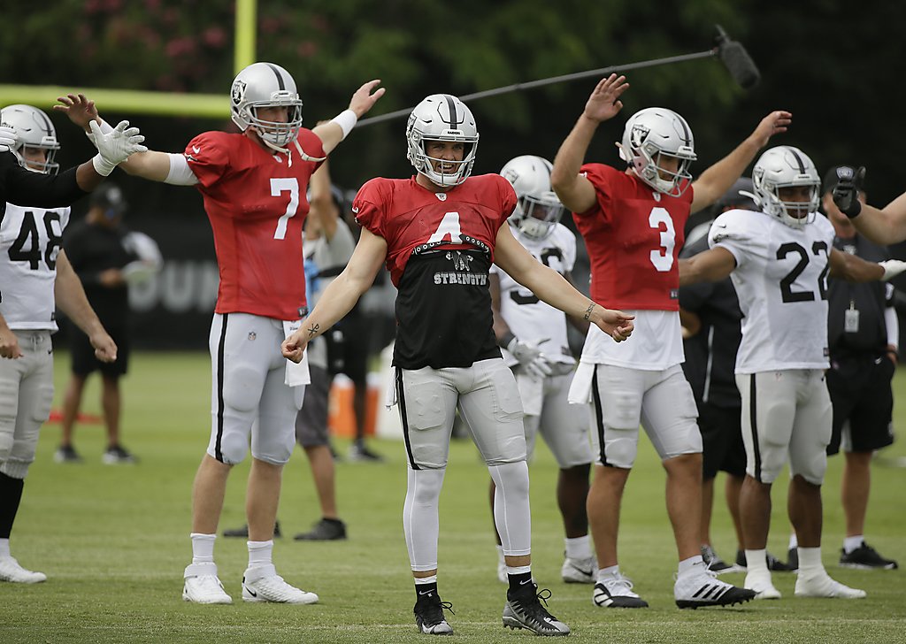 Oakland Raiders head coach Jon Gruen, left, confers with his quarterbacks Mike  Glennon (7), Landry Jones (2) and Derek Carr (4) during an NFL football  official team activity, Tuesday, May 21, 2019