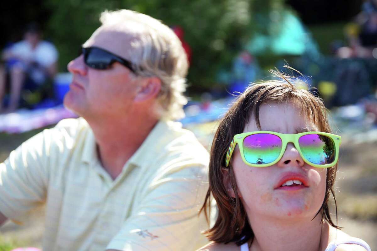 Nora Cizik, 11, and her father Alan, watch as the U.S. Navy Blue Angels perform on the final day of the annual Seafair Weekend at Genesee Park, Saturday, Aug. 3, 2019.