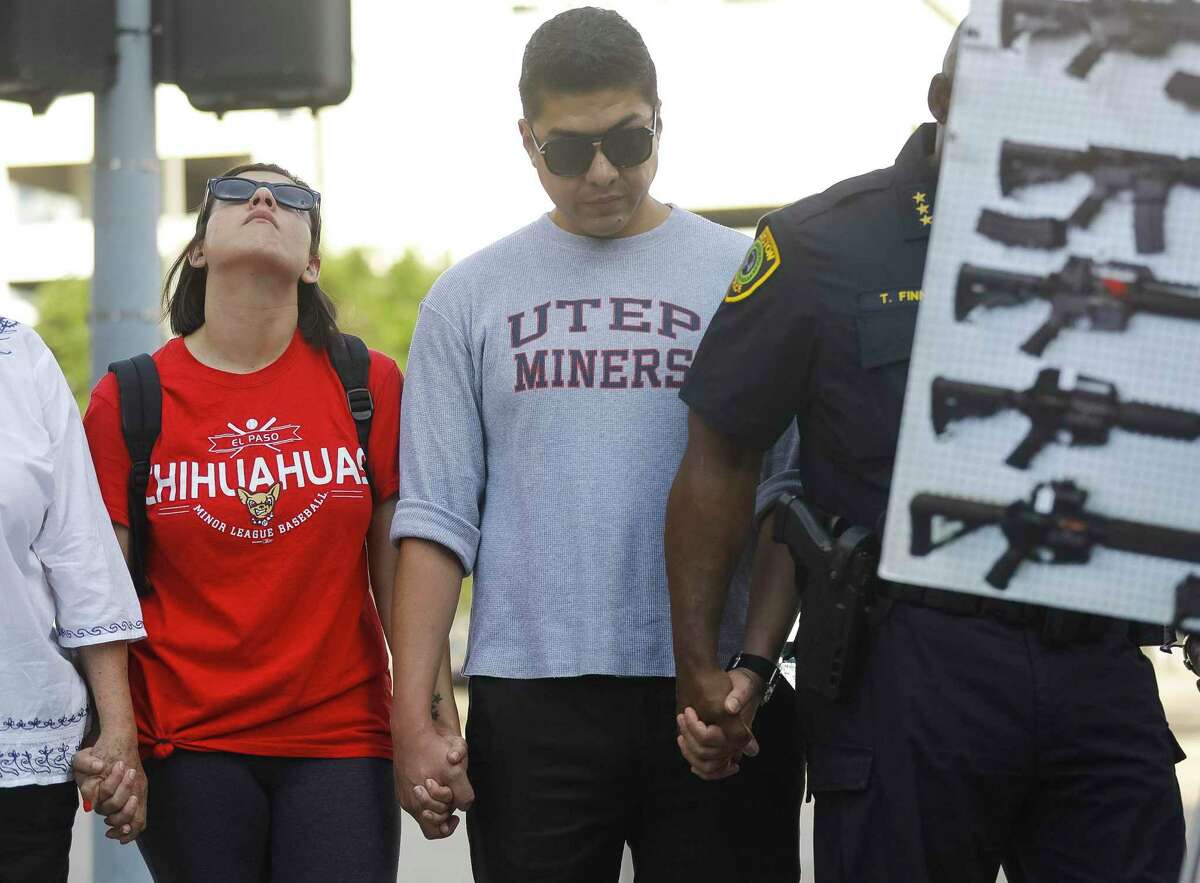 Stephanie Reveles and Adrian Lira, both originally from El Paso, participate in a gathering to honor the victims of the recent mass shootings in El Paso, TX and Dayton, OH, in downtown Houston, Sunday, Aug. 4, 2019.