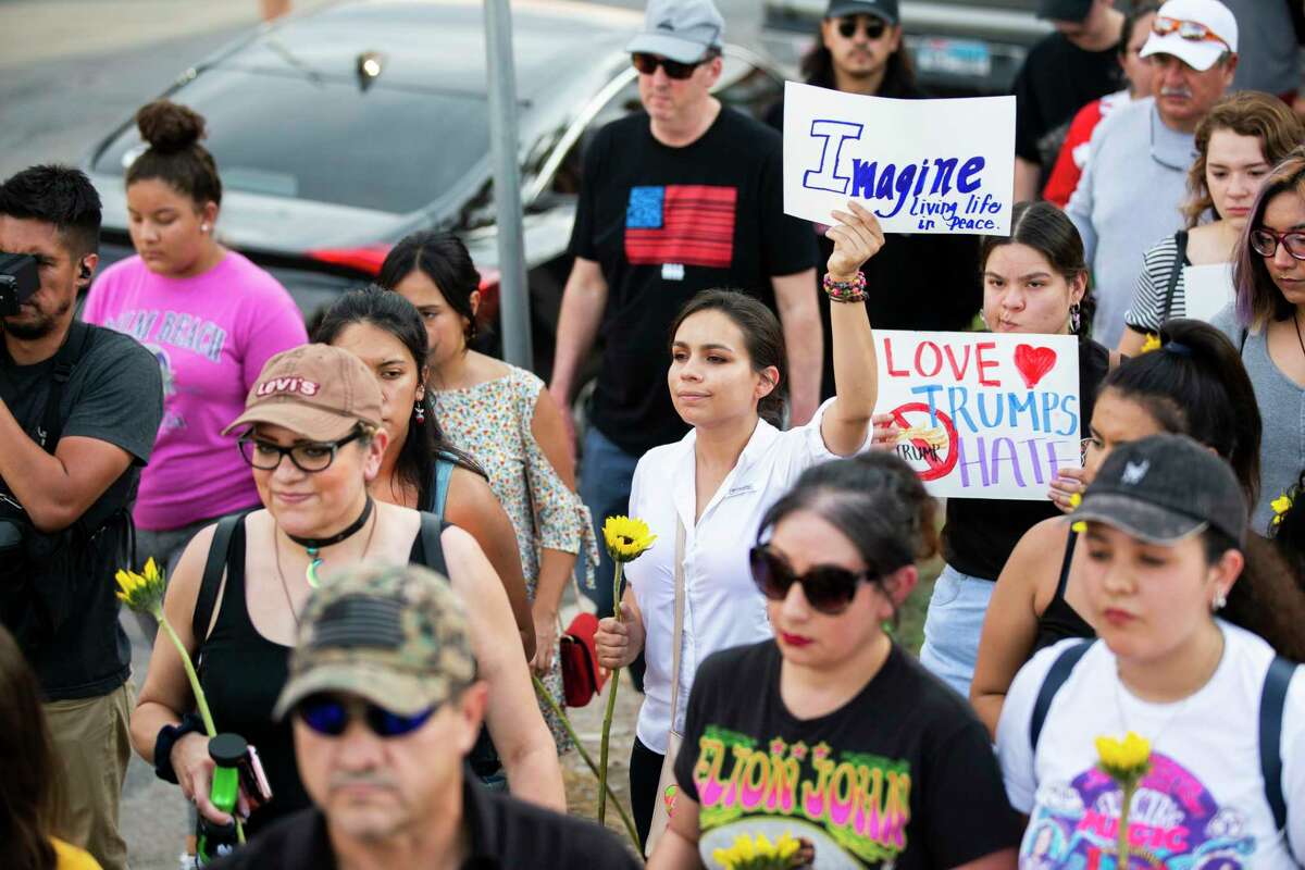 Protestors demonstrate in silence against violence during a procession holding signs on their way to Las Americas Headquarters Sunday, Aug. 4, 2019, in El Paso.