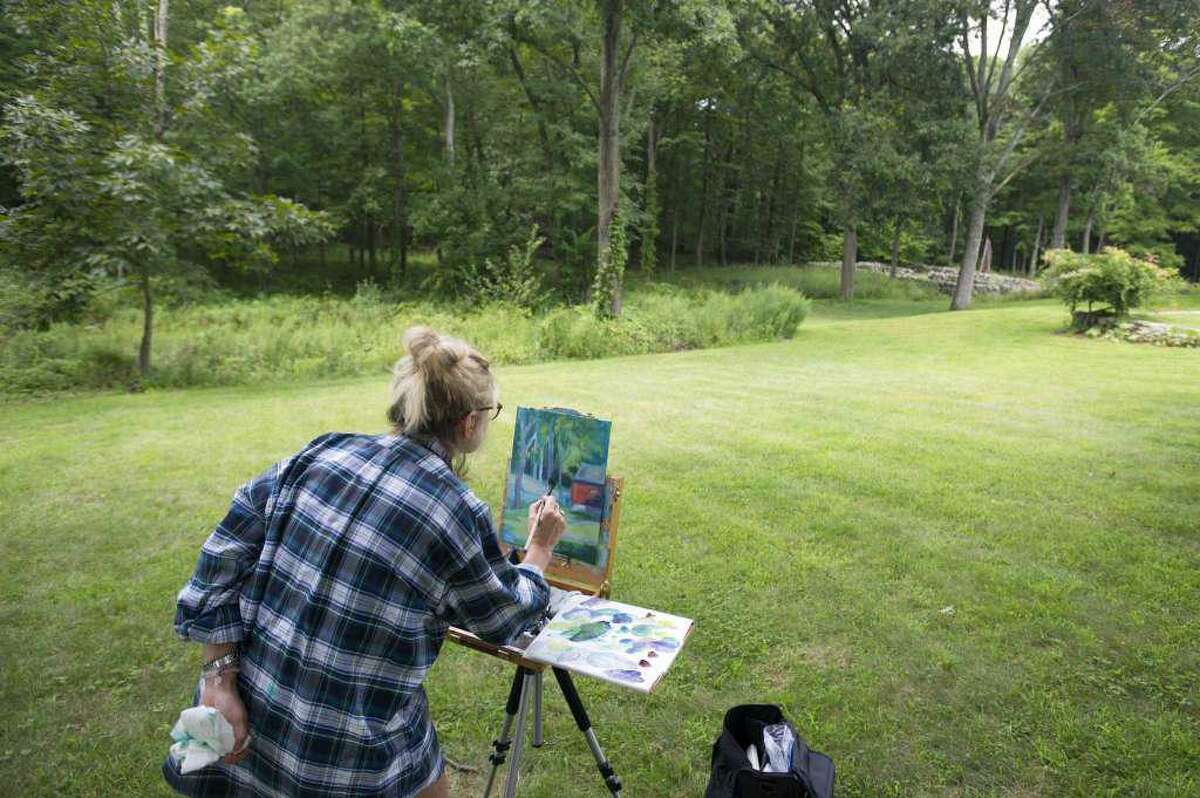 Artist Andrea McLaughlin, of Wilton, paints an outdoor scene in acrylics during the 2018 Art in the Park Festival.