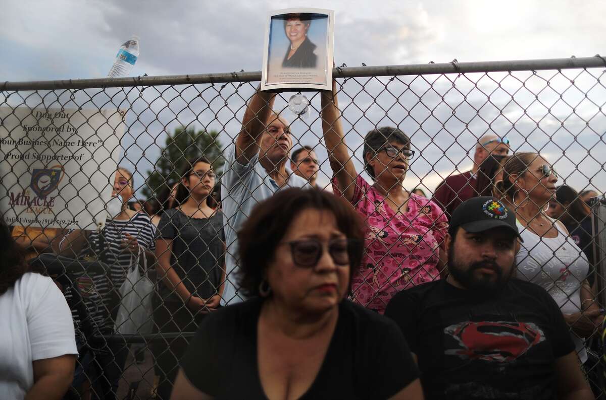 A photo (top) of Elsa Mendoza Marquez, a Mexican schoolteacher from Ciudad Juarez who was killed in the shooting, is held up during an interfaith vigil for victims of a mass shooting, which left at least 20 people dead, on August 4, 2019 in El Paso, Texas.