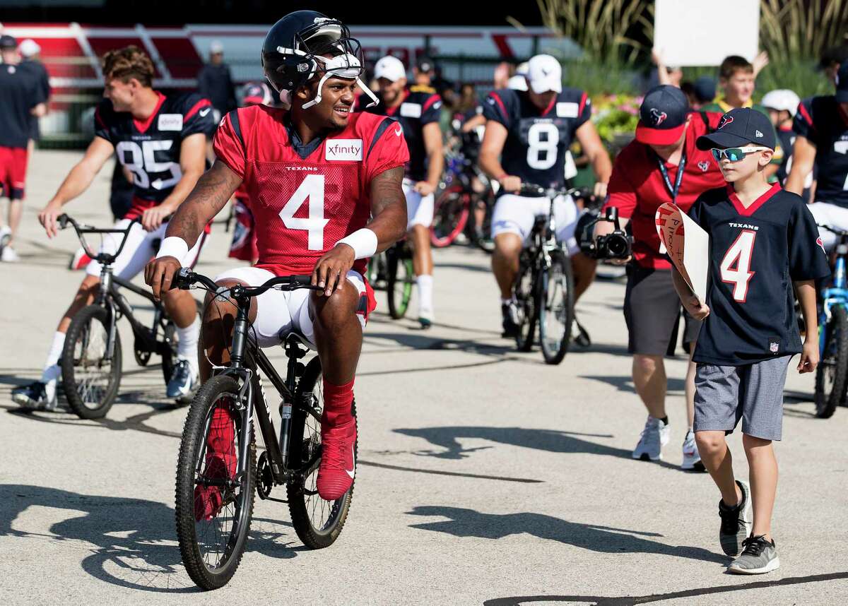 Houston Texans quarterback Deshaun Watson (4) rides a bike to a joint training camp practice with the Green Bay Packers on Monday, Aug. 5, 2019, in Green Bay, Wis.