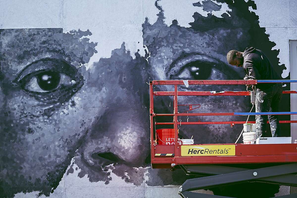 The artist Sean Michael Warren works on his mural that honors powerful black women and their resilience at the Dr. Maya Angelou Community High School in Los Angeles, May 2019. The mural is one of 28 works honoring Angelou that are now featured on the school’s grounds as part of a recent public arts project. (Carlos Gonzalez/The New York Times)