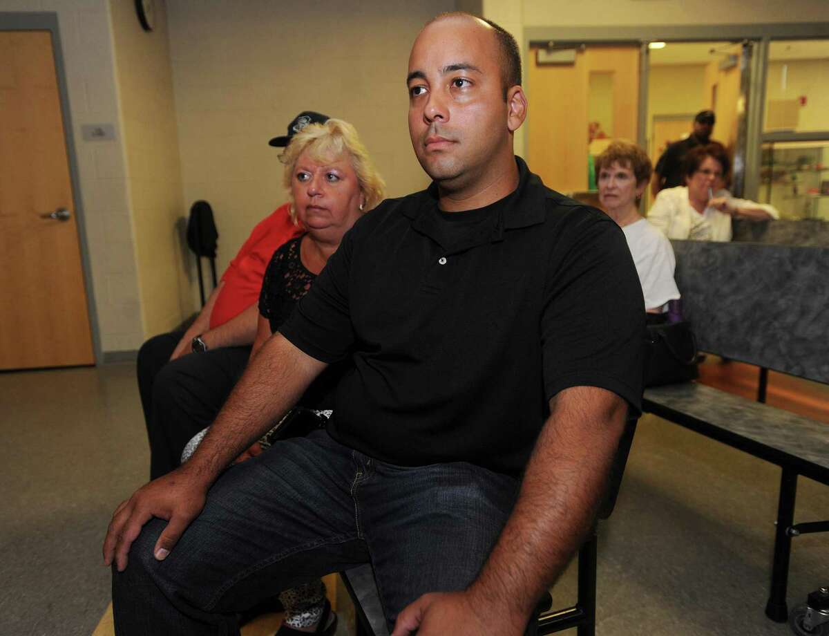 School Resource Officer Jonathan Forestier listens as Board of Education members vote to eliminate the remaining school officer positions during the board's meeting at Geraldine Johnson School in Bridgeport on June 27, 2016. Forestier is one of two former school police officers suing the city over their firings.