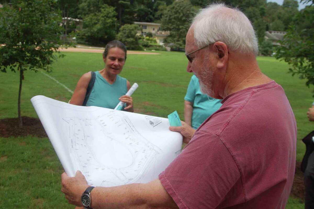 Binney Park Committee members Peter Uhry and Nancy Chapin look at plans for a new trail and other improvements that will be coming to Binney Park in the coming months.